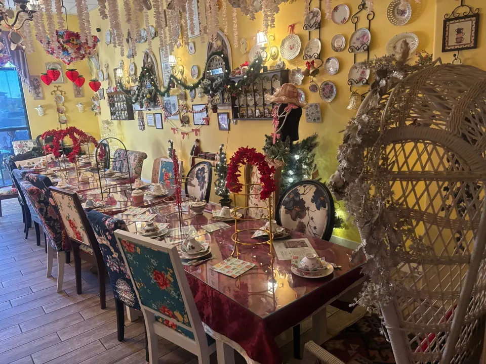 Elegant dining room with vintage decor and a long table set for tea.