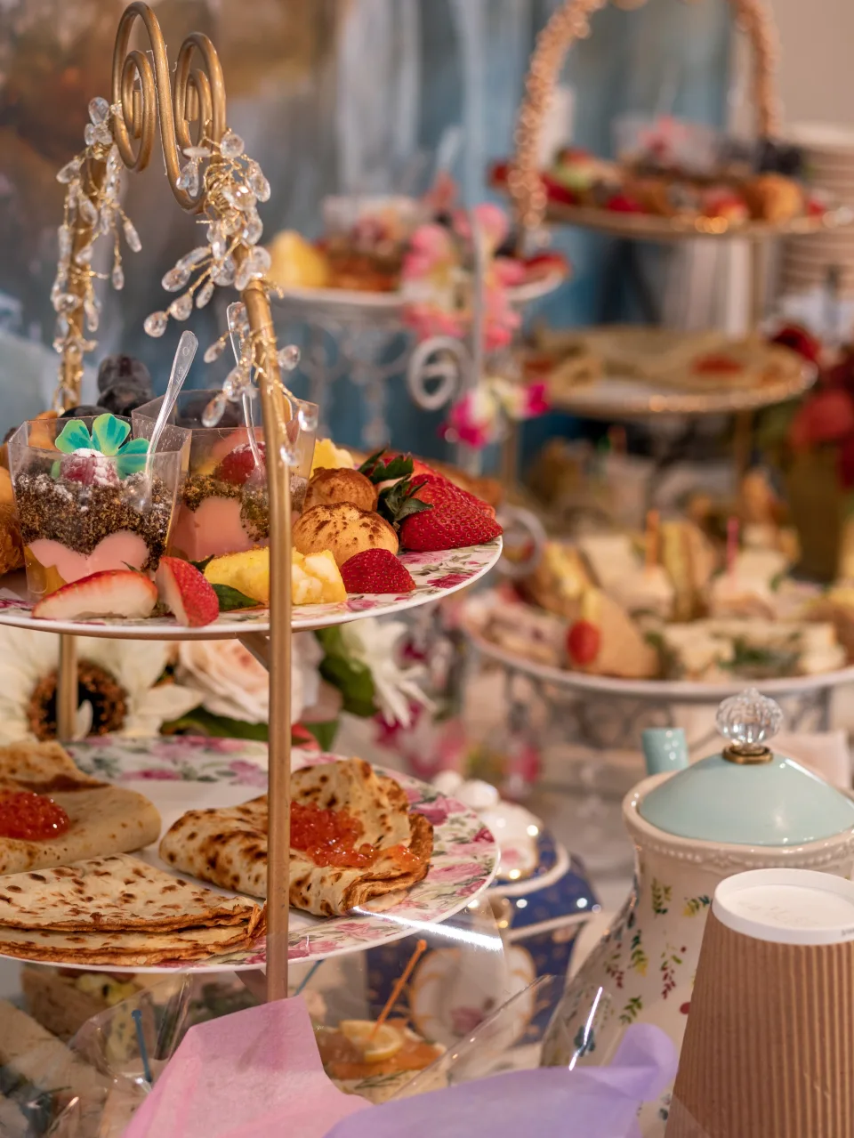 A gold afternoon tea stand filled with desserts, scones and savory bites at The Tea Terrace